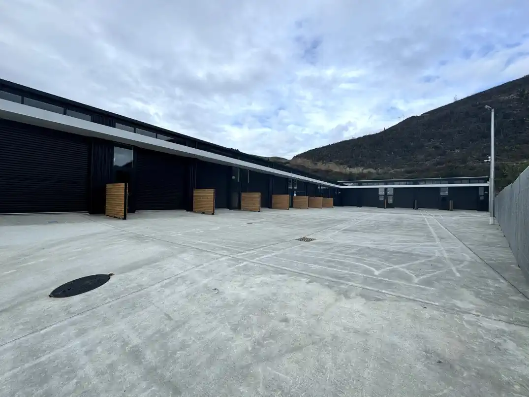 Row of units with roller doors and security fencing