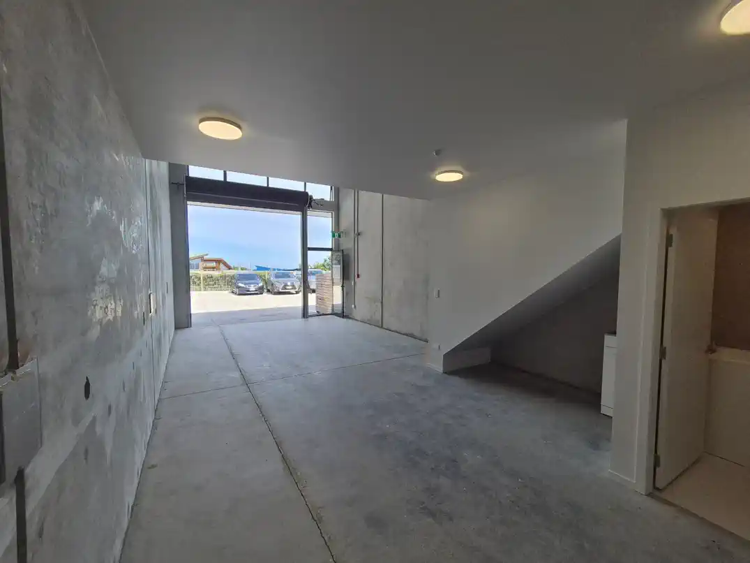 Interior ground floor open to the roller door with mezzanine and kitchenette