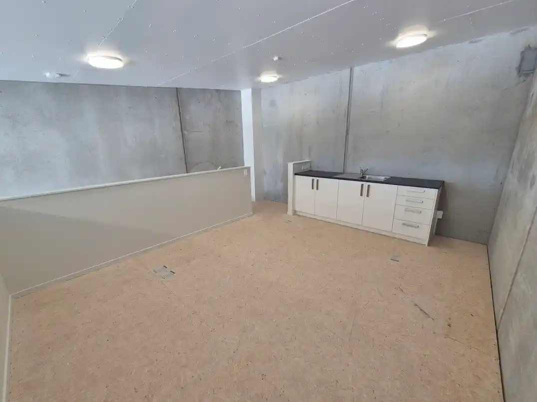 Mezzanine kitchenette with cabinetry and sink